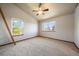 Bright bedroom features neutral walls, carpet, and a ceiling fan, complemented by natural light from large windows at 5861 E Valley Hi Dr, Parker, CO 80138