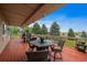 Spacious covered deck perfect for outdoor dining and entertaining, showcasing picturesque views of surrounding greenery at 5861 E Valley Hi Dr, Parker, CO 80138