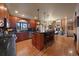 Open kitchen featuring wood cabinets, a center island with seating, and views into the living room at 5861 E Valley Hi Dr, Parker, CO 80138