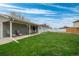 Expansive backyard with a covered patio, lush green lawn, and white fencing at 7472 Jay Ct, Arvada, CO 80003