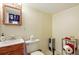Modest bathroom features a wood vanity, mirror, toilet, space heater, and chrome shelving unit at 7472 Jay Ct, Arvada, CO 80003