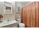 Cozy bathroom features a single sink vanity, toilet, and shower with a striped curtain at 7472 Jay Ct, Arvada, CO 80003