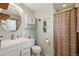 Well-lit bathroom featuring a modern vanity, medicine cabinet, and shower with curtain at 7472 Jay Ct, Arvada, CO 80003