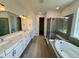 Contemporary bathroom with double vanity, a soaking tub, and a glass-enclosed shower at 229 Wooten Ave, Brighton, CO 80601