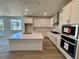 Modern kitchen featuring a large island, stainless steel appliances, and bright white cabinetry at 229 Wooten Ave, Brighton, CO 80601
