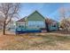 Backyard view of a home featuring a cozy deck and well-maintained lawn at 4270 Defoe St, Strasburg, CO 80136
