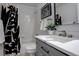 Clean bathroom features shower-tub combination, patterned curtain, and a large mirror above the sink at 4270 Defoe St, Strasburg, CO 80136