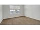 Empty bedroom with plush carpeting and a large window at 4270 Defoe St, Strasburg, CO 80136