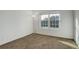 Empty bedroom features a carpeted floor, a lamp, and a window at 4270 Defoe St, Strasburg, CO 80136
