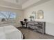 Bedroom with a wooden dresser, modern mirrors, and a dedicated computer work space by the window at 4270 Defoe St, Strasburg, CO 80136