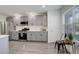 Bright kitchen with gray cabinets, stainless steel appliances, and white countertops at 4270 Defoe St, Strasburg, CO 80136