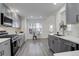Modern kitchen featuring gray cabinetry, stainless steel appliances, and sleek countertops at 4270 Defoe St, Strasburg, CO 80136