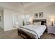 Cozy main bedroom with a rustic wood bed frame, ensuite bath, and neutral decor at 4270 Defoe St, Strasburg, CO 80136