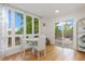 Bright dining area featuring hardwood floors, a white round table, and sliding glass doors to the backyard at 5831 W 108Th Pl, Westminster, CO 80020