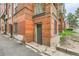 Image shows the exterior of the brick apartment building, including a back door and grated windows at 1376 N Pearl St # B1, Denver, CO 80203