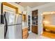 Cozy kitchen with stainless steel refrigerator, wooden cabinets, and an adjacent sunlit bedroom at 1376 N Pearl St # B1, Denver, CO 80203