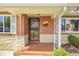 Inviting brick porch with stone accents and ornamental metal supports offers classic charm at 375 Kohl St, Broomfield, CO 80020