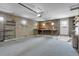 Spacious garage featuring block walls, an automatic door, shelving, and a workbench area at 375 Kohl St, Broomfield, CO 80020