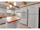 Bright kitchen featuring white cabinets, wood countertops, an island, and stainless steel appliances at 375 Kohl St, Broomfield, CO 80020