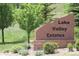Stone sign at Lake Valley Estates entrance, surrounded by greenery, welcomes residents and visitors at 4133 Niblick Dr, Longmont, CO 80503