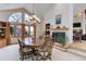 Dining room with a fireplace, large windows, and a chandelier lighting a wooden table at 4133 Niblick Dr, Longmont, CO 80503