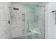Elegant walk-in shower with sleek marble tiling, a rainfall showerhead, and a built in bench at 4133 Niblick Dr, Longmont, CO 80503