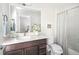 Bright bathroom with a modern vanity, stylish mirror, and a shower-tub combination at 1581 Wolff St, Denver, CO 80204