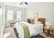 Bright bedroom with two windows, ceiling fan, bench and a decorative bed with pillows at 1581 Wolff St, Denver, CO 80204