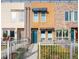 Inviting townhome with a colorful door, and charming yard with a decorative fence that adds character and curb appeal at 1581 Wolff St, Denver, CO 80204