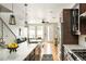Modern kitchen featuring stainless steel appliances, a large island, and an open layout to the living area at 1581 Wolff St, Denver, CO 80204