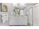 Bathroom featuring double sinks, modern fixtures, and glass shower; clean and pristine at 4837 Cattle Cross Ln, Castle Rock, CO 80104