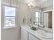 Bathroom with double sinks, ample counter space, and a large window providing natural light at 4837 Cattle Cross Ln, Castle Rock, CO 80104