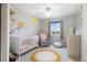 Charming Bedroom with playful giraffe wall art, soft rug and white crib at 1540 Meachum Way, Erie, CO 80516