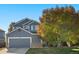 Charming blue two-story home with stone accents, mature landscaping, and an attached two-car garage at 1540 Meachum Way, Erie, CO 80516