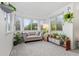 Sun-filled sitting area with large windows, plants, and a comfortable light grey sofa at 1540 Meachum Way, Erie, CO 80516