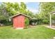 Backyard view of a charming shed with surrounding green grass and landscaping at 3317 Harlan St, Wheat Ridge, CO 80033