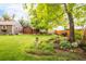 Green backyard with a lush garden, bird bath, and wooden fence at 3317 Harlan St, Wheat Ridge, CO 80033