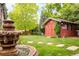 Well-manicured lawn featuring a charming shed and decorative fountain at 3317 Harlan St, Wheat Ridge, CO 80033