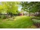 Wide backyard with flowerbeds and lawn and multiple structures and trees at 3317 Harlan St, Wheat Ridge, CO 80033