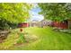 Lush backyard with vibrant garden, manicured lawn, and multiple structures at 3317 Harlan St, Wheat Ridge, CO 80033