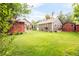 Spacious backyard with lush green lawn, multiple structures and mature trees at 3317 Harlan St, Wheat Ridge, CO 80033