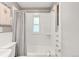 Bright bathroom featuring a window over the tub and white tiled walls at 3317 Harlan St, Wheat Ridge, CO 80033