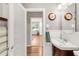 Half bathroom with a white sink, wood trim and a view of the living room at 3317 Harlan St, Wheat Ridge, CO 80033