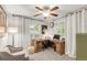 Bedroom with a light colored armchair and wooden desk under windows with white curtains at 3317 Harlan St, Wheat Ridge, CO 80033