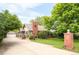 Charming exterior features a well-maintained lawn, a brick chimney, and a detached two car garage with a long driveway at 3317 Harlan St, Wheat Ridge, CO 80033