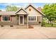 View of the front exterior showcasing its well-kept facade, including the front entryway, neutral paint and shuttered windows at 3317 Harlan St, Wheat Ridge, CO 80033