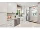 Bright kitchen features a farmhouse sink, stainless steel appliances, and quartz countertops at 3317 Harlan St, Wheat Ridge, CO 80033