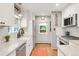 White kitchen features stainless steel appliances, quartz countertops, and hardwood floors at 3317 Harlan St, Wheat Ridge, CO 80033