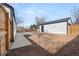Backyard with concrete patio leading to a detached garage and wooden fence at 2990 S Elm St, Denver, CO 80222