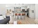 Open-concept kitchen with white cabinets, modern appliances, and island with bar seating at 2990 S Elm St, Denver, CO 80222